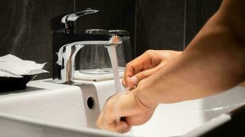 Man's hand is pouring in the sink in one of the luxury bathrooms on the property. photo