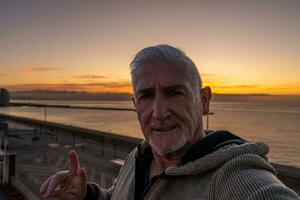 contento hermoso medio Envejecido hombre tomando un selfie en el cubierta de un crucero Embarcacion foto