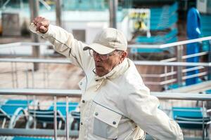 hermoso contento medio Envejecido hombre teniendo divertido bailando en el cubierta de un crucero Embarcacion foto