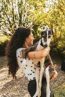 beautiful female instructor hugs her dog during a training break photo