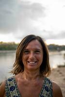 portrait of beautiful middle aged woman posing on the banks of the river photo