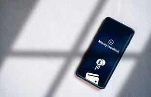 Top view of smartphone transfering money online on screen. Concept of financial transactions with mobile devices. Smartphone screen displaying money transfer confirmation. photo