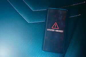 Flat lay photo of smartphone with system hacked alert on screen. Compromised information concept. Internet virus cyber security and cybercrime.