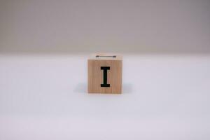 Wooden block written I with a white background, education concept, close up. photo