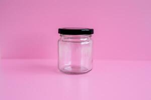 1 empty jar, black lid, with a pink scene, close up. photo