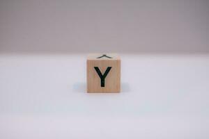 Wooden block written Y with a white background, education concept, close up. photo