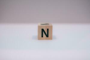 Wooden block written N with a white background, education concept, close up. photo