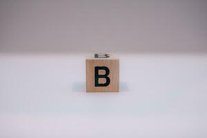 Wooden block written B with a white background, education concept, close up. photo