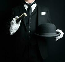 retrato de mayordomo en oscuro formal traje y blanco guantes cepillado un jugador de bolos sombrero. concepto de Servicio industria y profesional hospitalidad. foto