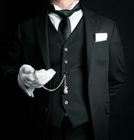 Portrait of Formal Butler in Dark Suit and White Gloves Holding Pocket Watch. Service Industry and Professional Hospitality. photo