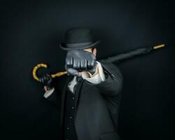 Portrait of Gentleman in Dark Suit and Bowler Hat Holding an Umbrella and Throwing a Punch. Vintage English Gentleman Man of Action. photo