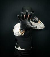 Portrait of Dangerous Vintage Fighter in Vest and Bowler Hat Standing in Karate Stance. Mobster in Black Leather Gloves. photo