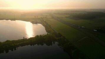 antenne visie van een rivier- en een meer Bij zonsondergang video