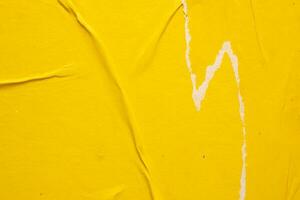 Old grunge ripped torn yellow paper poster surface texture background photo