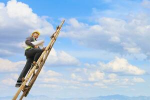 Asian business man engineer climbing up ladder with blue sky, career growth and success concept photo