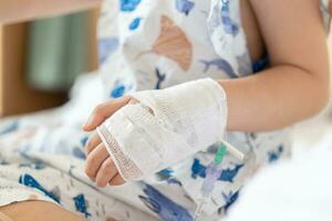 Close up child hand with saline IV solution in hospital photo