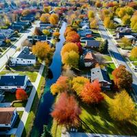 gastos generales aéreo ver de vistoso otoño árboles, residencial casas, y yardas con drenaje estanque a lo largo un suburbano calle en el chicago área. foto