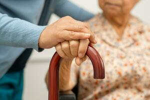 Caregiver help Asian elderly woman patient with love, care, encourage and empathy at nursing hospital, healthy strong medical concept. photo