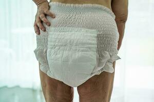 Asian senior woman patient wearing incontinence diaper in hospital, healthy strong medical concept. photo