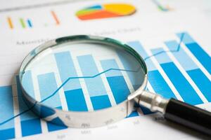 Magnifying glass on graph paper. Financial development, Banking Account, Statistics, Investment Analytic research data economy, Business concept. photo