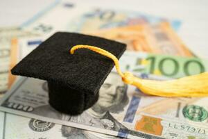 Sombrero de brecha de graduación en billetes de euro y dólar estadounidense, concepto de enseñanza de aprendizaje de tarifa de estudio de educación. foto