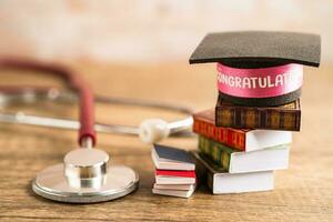 Stethoscope with graduation hat on book with copy space, learning university education concept. photo