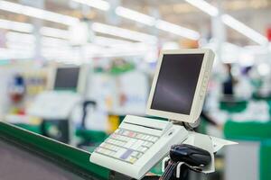 Empty cashier checkout desk with terminal in supermarket photo