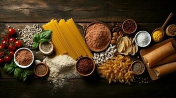 Gluten free food. Various pasta, bread, snacks and flour on wooden background from top view photo