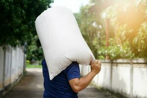 ack view of strong man holding heavy sack on his shoulders. Concept, hard- working, laborer. Working against poverty. Man carry sack to delivery. Service to home. Lifestyle photo