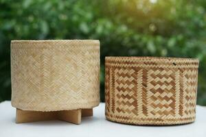 Woven bamboo rice box in cylinder shape for contain sticky rice. Concept , handmade, handicraft. Thai wisdom to use natural materials to be kitchenwares. Safety food with nature  container. photo