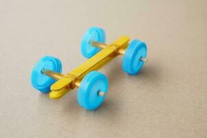 Handmade toy racing car made from ice cream sticks and bottle caps. Concept, Recycling kids toy.Easy to do, creative DIY craft that kids can do. Fun lesson to support kid imagination development. photo