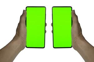 Human hand showing mobile smartphone with green screen in vertical position isolated on white background. photo