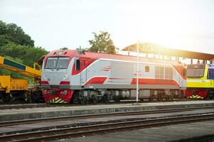 un tren de diesel trenes entrando el plataforma carga y pasajero trenes foto