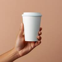 a person holding a paper coffee cup in his hand photo