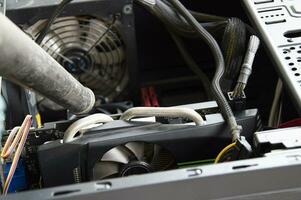 Photograph of a technician blowing dust from a computer photo