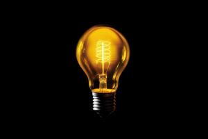 a yellow light bulb on a black background photo