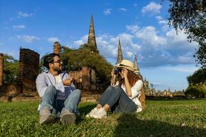 Pareja de exterior turistas utilizar cámara a tomar foto a wat phra si sanphet templo, ayutthaya tailandia, para viajar, vacaciones, día festivo, Luna de miel y turismo concepto