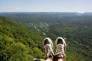 hiking boots having fun and enjoying wonderful breathtaking mountain view. Lifestyle and travel concept. photo