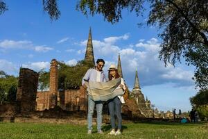 Couple of tourist come to visit at Wat Phra Si Sanphet temple, Ayutthaya Thailand using maps for travel, vacation, holiday, honeymoon and tourism photo