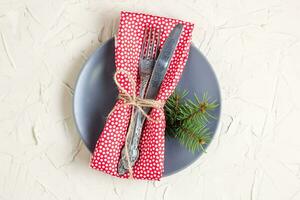 Christmas menu background with fork knife napkin and fir tree brunch on white table. Copy space, top view photo