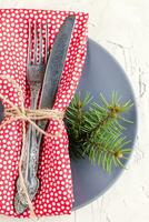 Christmas menu background with fork knife napkin and fir tree brunch on white table. top view photo