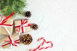 Christmas or New Year decorations background with pine cones, fir branches, gift boxes, and candy canes photo