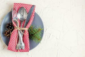 Christmas menu background with fork knife napkin and fir tree brunch on white table. Copy space, top view photo