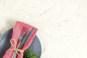 Christmas menu background with fork knife napkin and fir tree brunch on white table. Copy space, top view photo