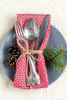 Christmas menu background with fork knife napkin and fir tree brunch on white table. top view photo