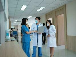 Doctor nurse staff assistance male female man woman person people wear mask talk speak discussion report history patient medical ward hospital clinic work job occupation teamwork healthcare profession photo
