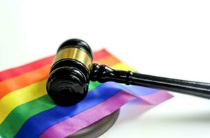 wood gavel of lawyer on colorful rainbow pride flags on white background,concept of lgbt equality community movement claims for the rights by court or legal for lgbtq people life,love,family,marriage photo