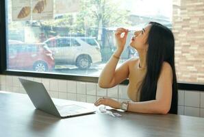 woman doing self test ATK by looking the example from internet laptop on desk, concept ATK self test for Covid-19 screening photo