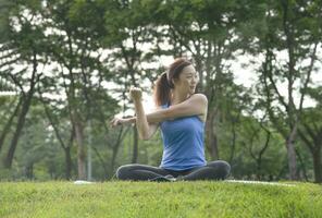 young asian woman doing yoga in the park.cold yoga is a popular yoga practice,practicing in a well ventilated area like a park or playing in a room with normal,can practice for a long time photo