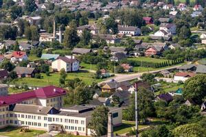 panoramic aerial view of eco village with wooden houses, gravel road, gardens and orchards photo